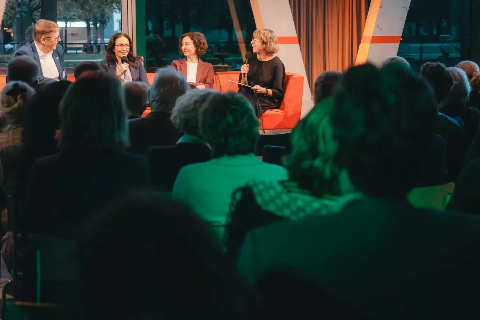 Blick durch zuschauerköpfe aufs Podium, wo Jörg-Andreas Krüger, Yasmin Fahimi, Ramona Pop und Hanna Gersmann debattieren
